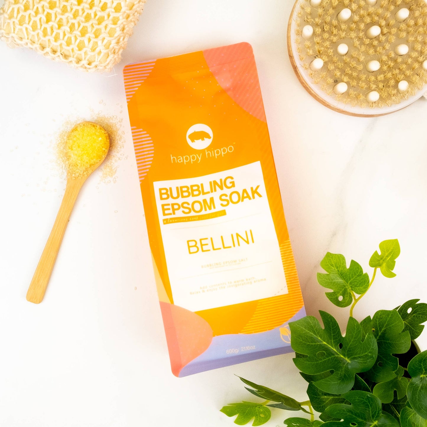 Happy Hippo Bubbling Epsom Soak Bellini package on a white background with a plant and bath accessories.