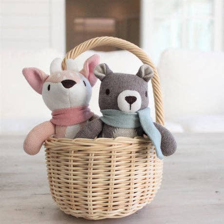 
                  
                    Two stuffed animals, a deer and a bear, in a wicker basket with a blurred background.
                  
                