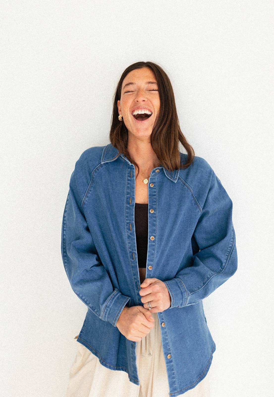 
                  
                    Woman wearing a blue denim shirt against a white background
                  
                