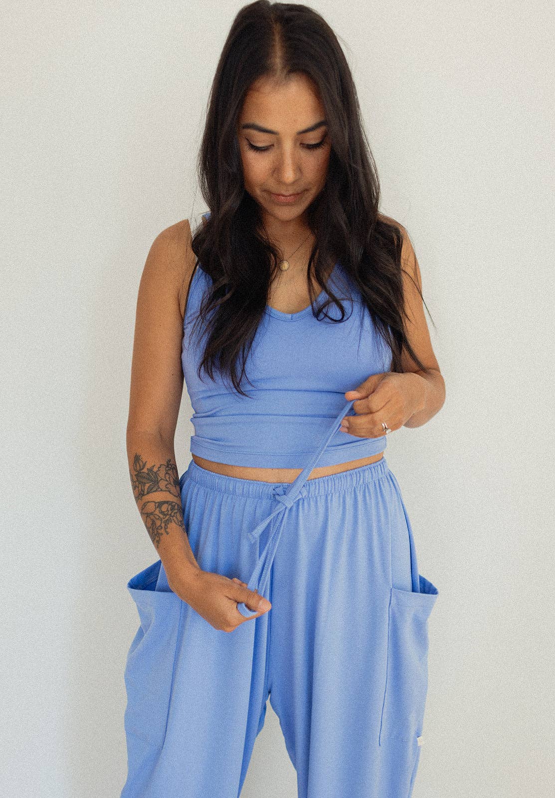 Woman wearing a blue athletic outfit against a white background
