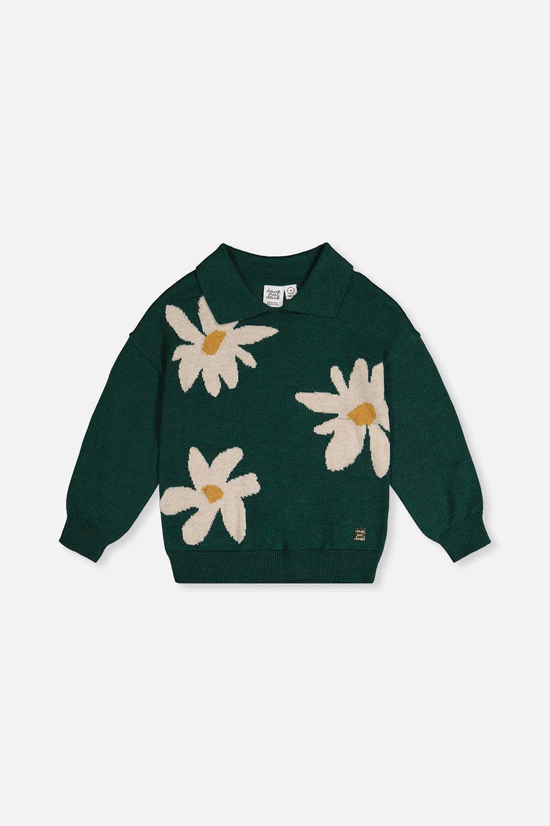 Green sweater with white daisy patterns on a light gray background.