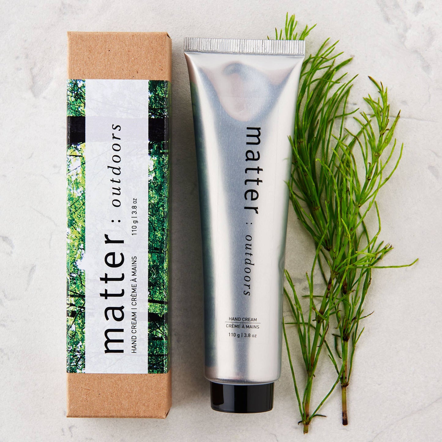 
                  
                    Hand cream tube and packaging with greenery on a light background
                  
                