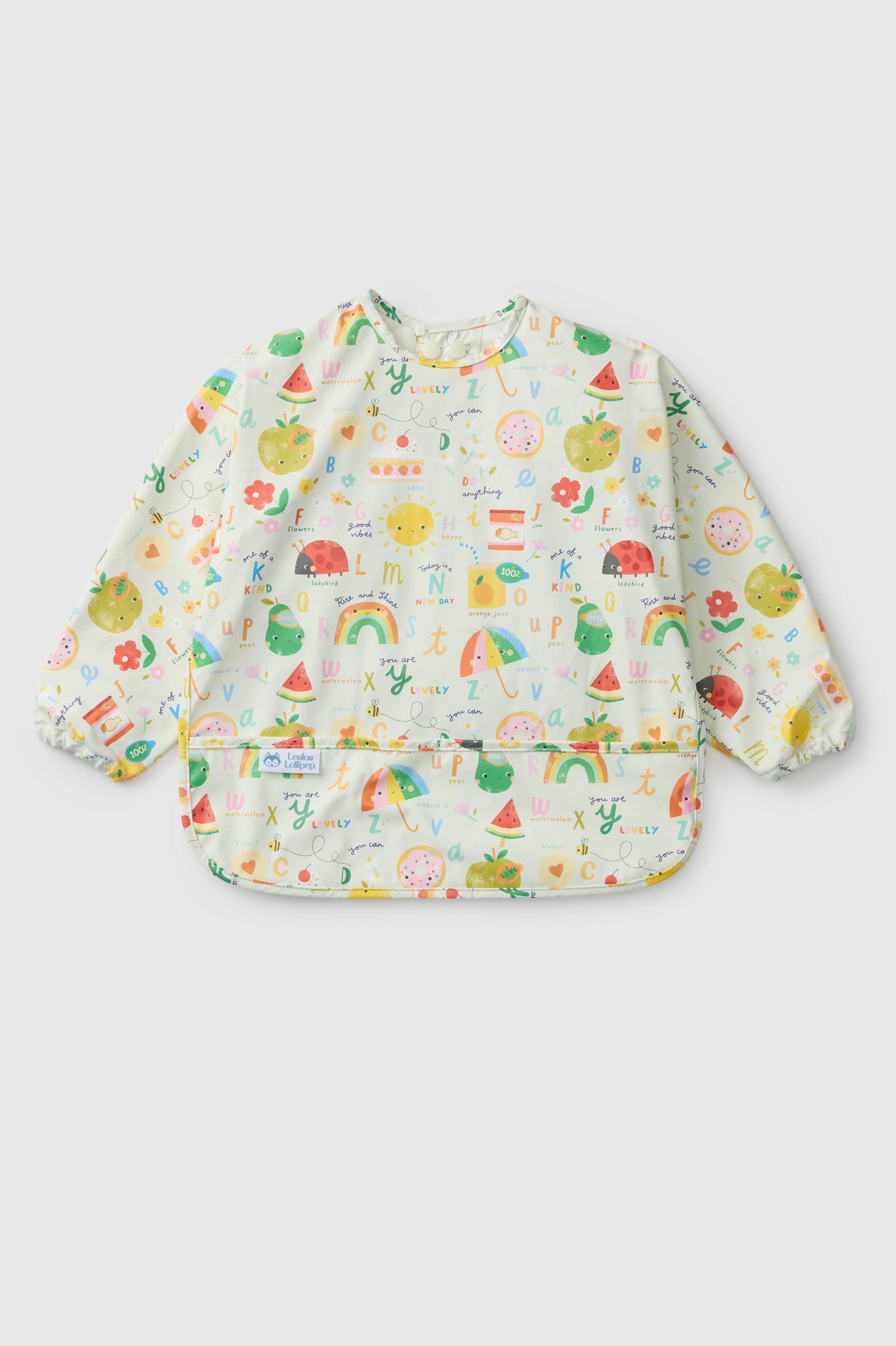 Baby bib with colorful fruit and rainbow pattern on a light gray. background