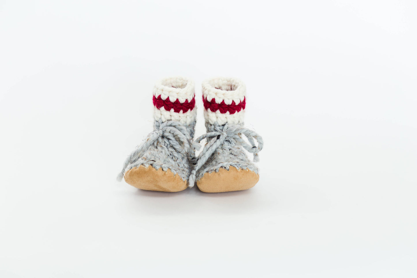 
                  
                    Grey, red and white wool booties against a white background. 
                  
                