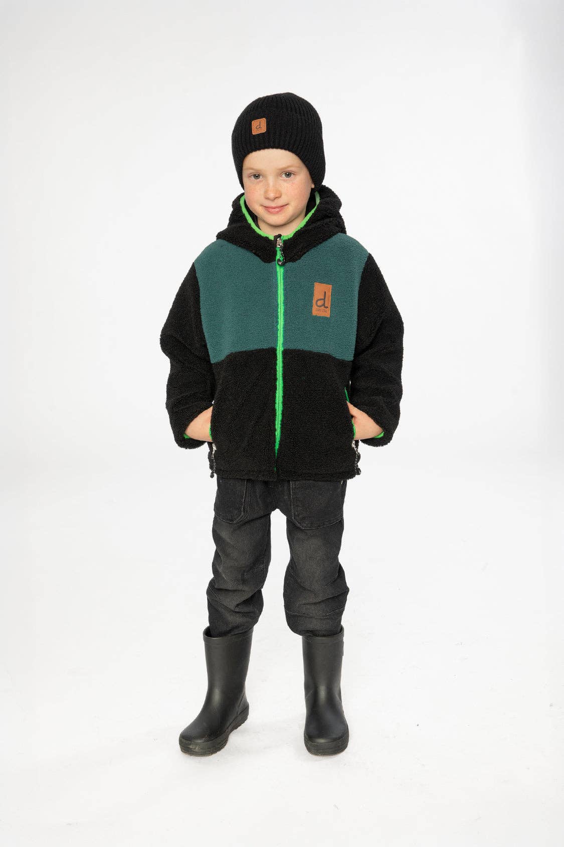 
                  
                    Child wearing a green and black jacket with a white background. 
                  
                