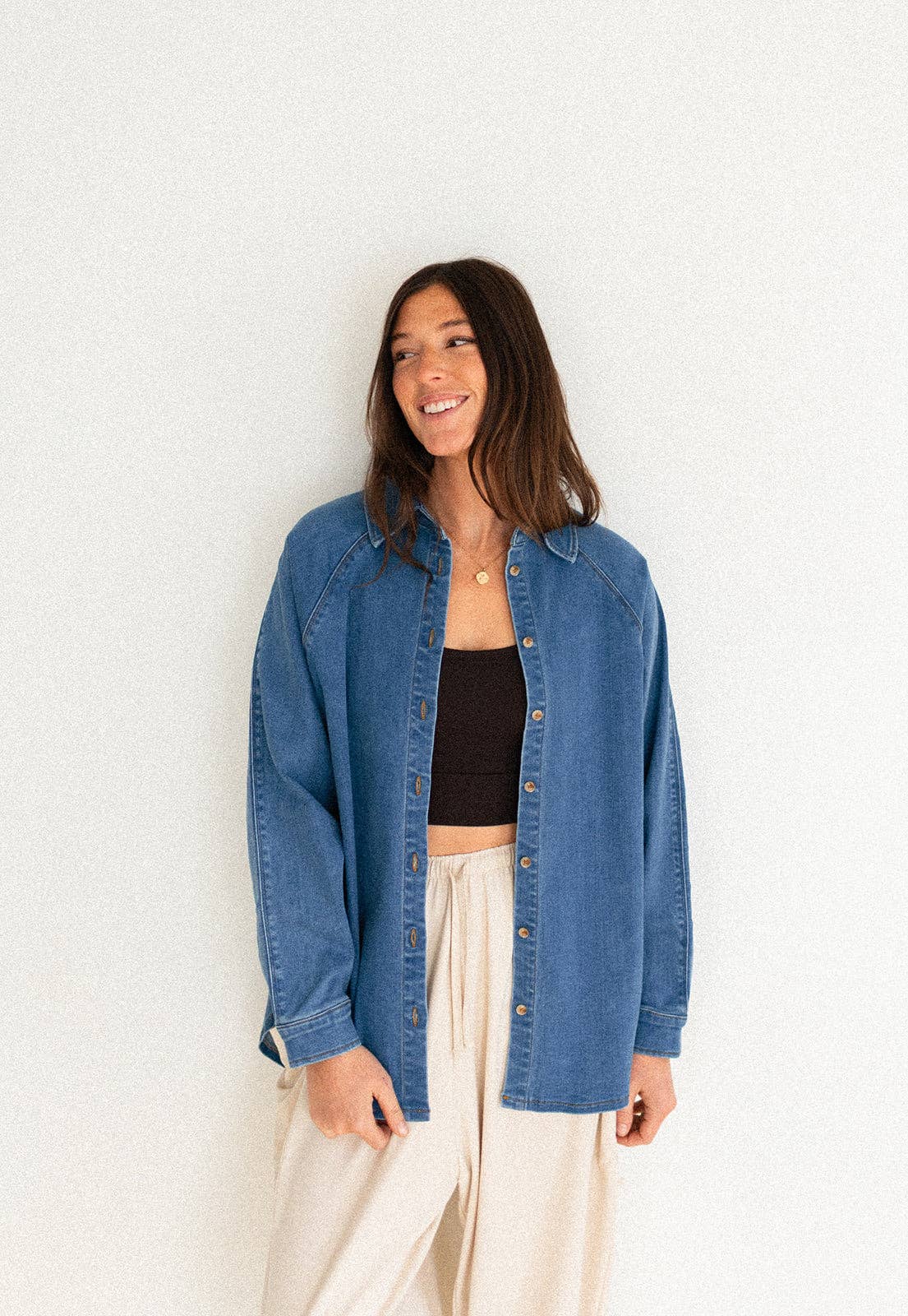 Woman wearing a blue denim jacket against a white background