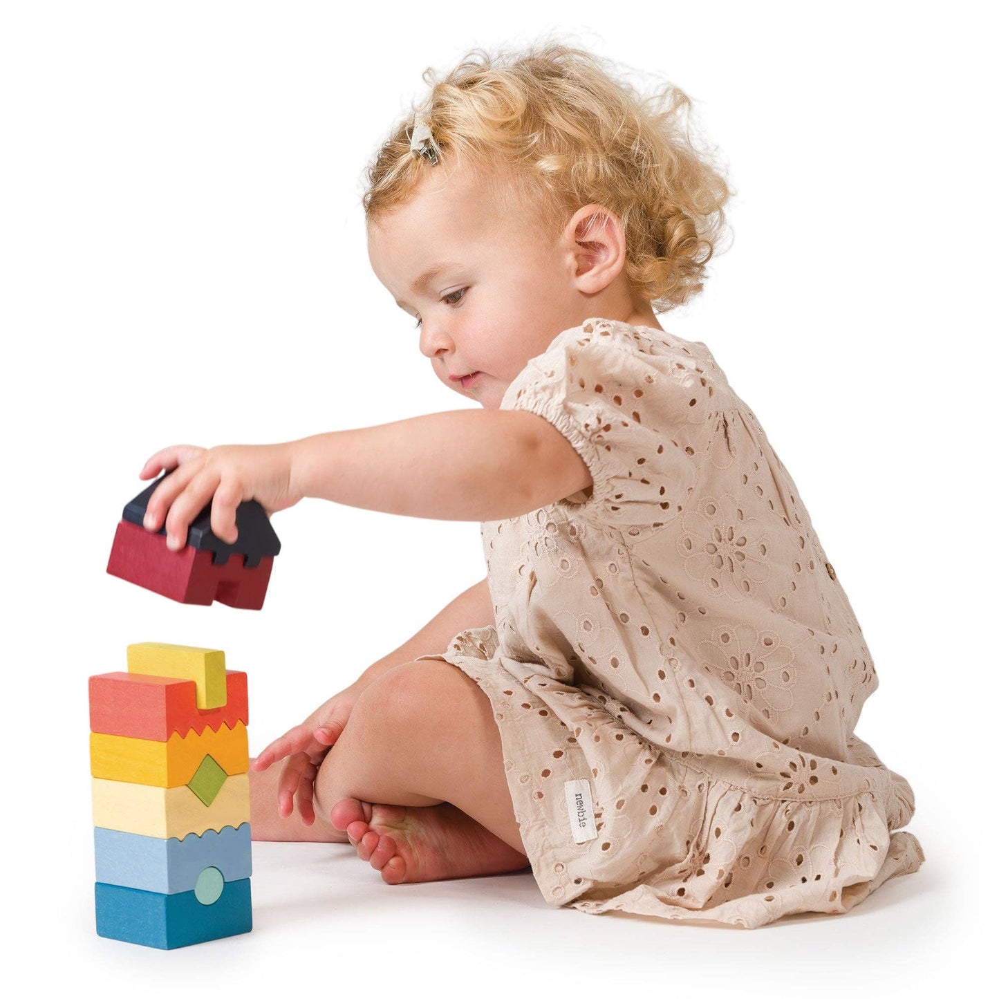 
                  
                    Child playing with colorful building blocks on a white background.
                  
                