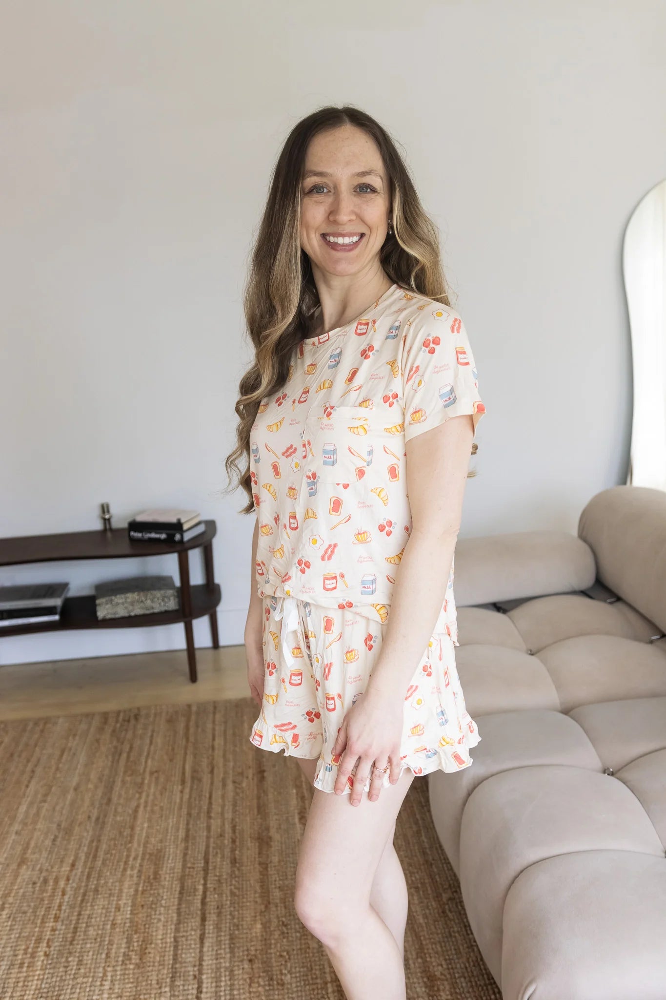 
                  
                    Woman in a patterned pajama set standing in a living room.
                  
                