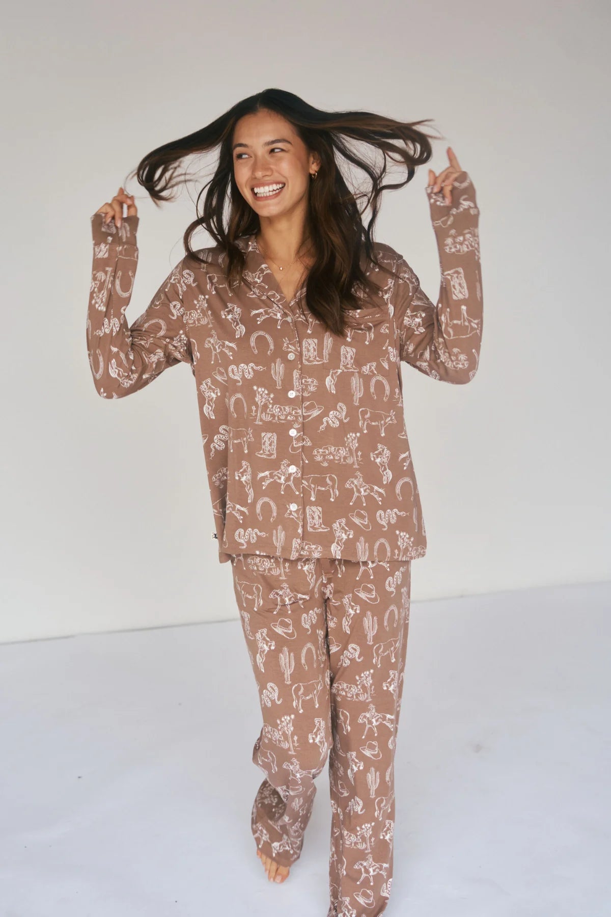 
                  
                    Woman wearing a brown patterned pajama set on a white background.
                  
                