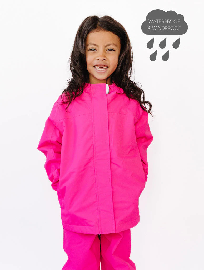 
                  
                    Child wearing a bright pink raincoat and pants on a white background
                  
                