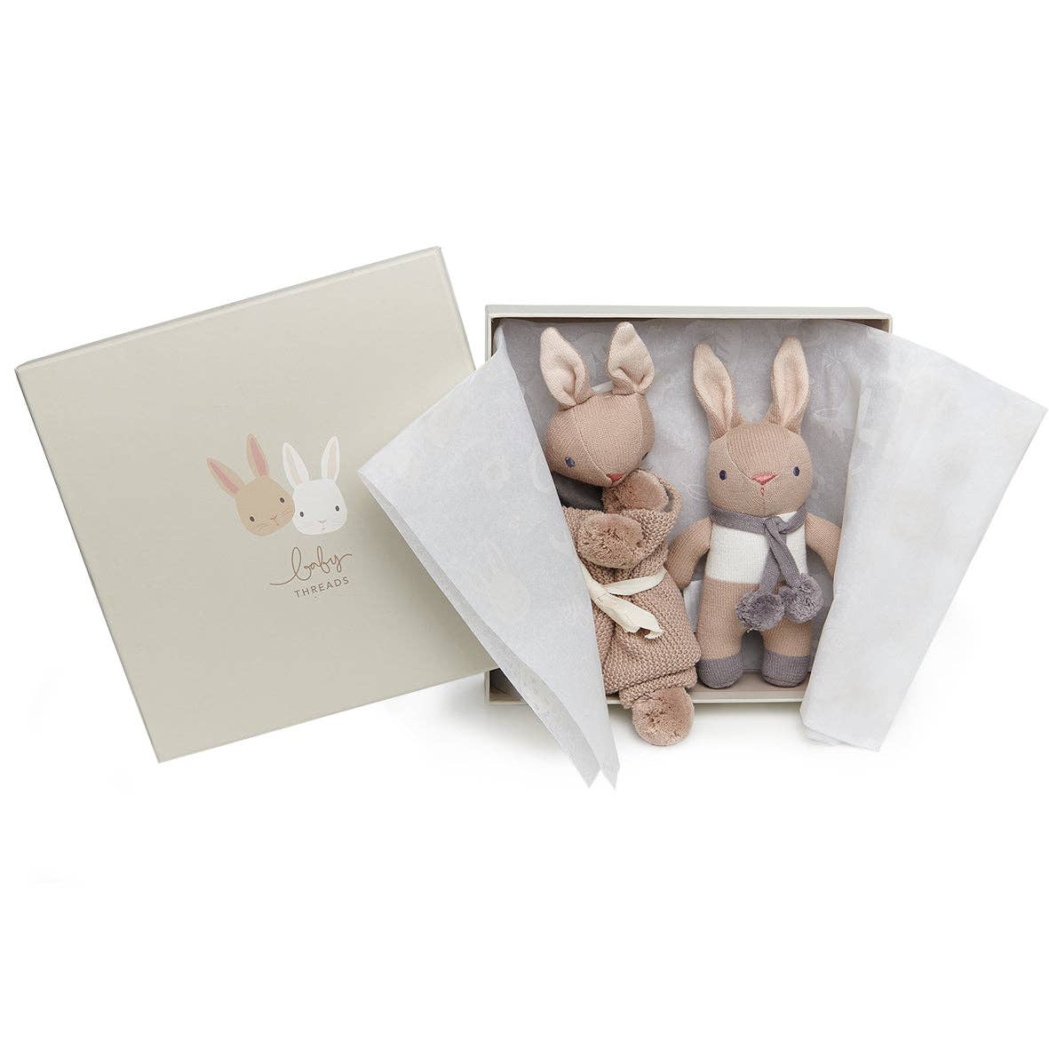Two plush rabbit toys in a gift box with a beige cover featuring rabbit illustrations.