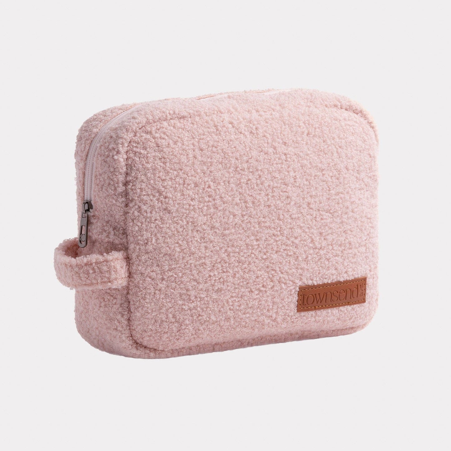 Pink teddy pouch with a brown patch on a light gray background.