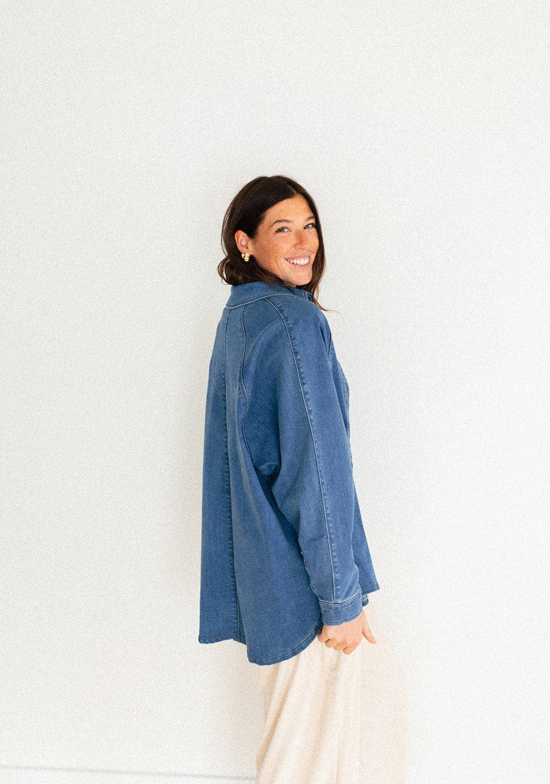 
                  
                    Woman wearing a blue denim shirt against a white background
                  
                