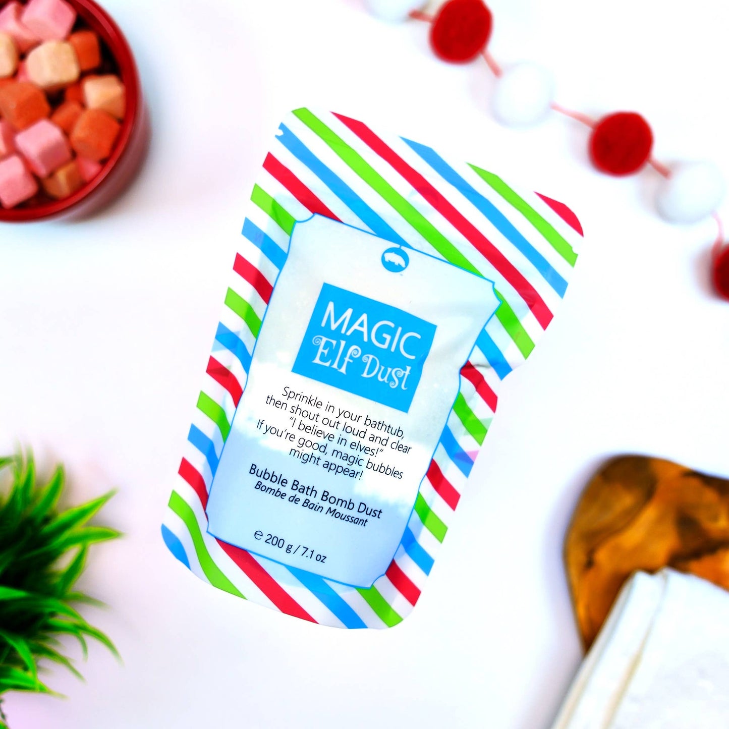 Colorful packaging of 'Magic Elf Dust' bubble bath bomb dust with a white background.