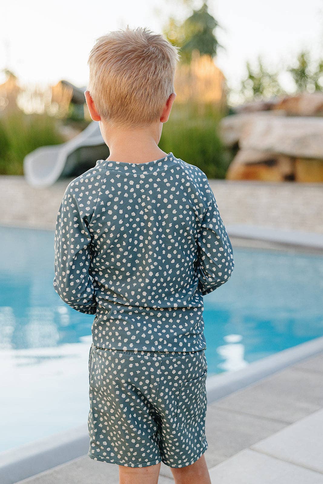 
                  
                    Child wearing a polka dot swimsuit by a pool
                  
                