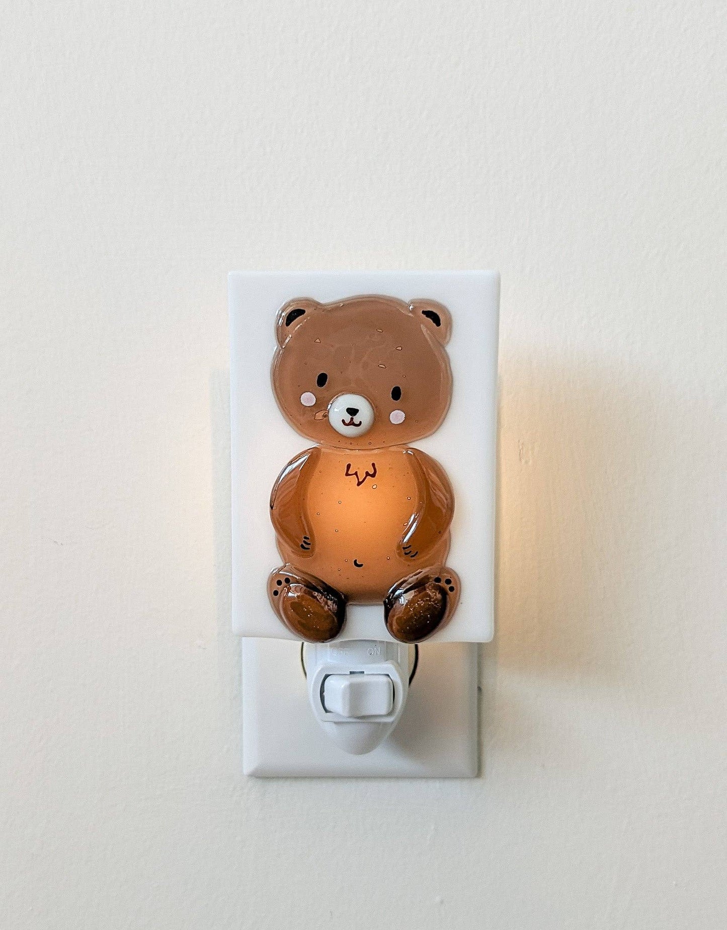 
                  
                    Bear-shaped night light on a white wall.
                  
                