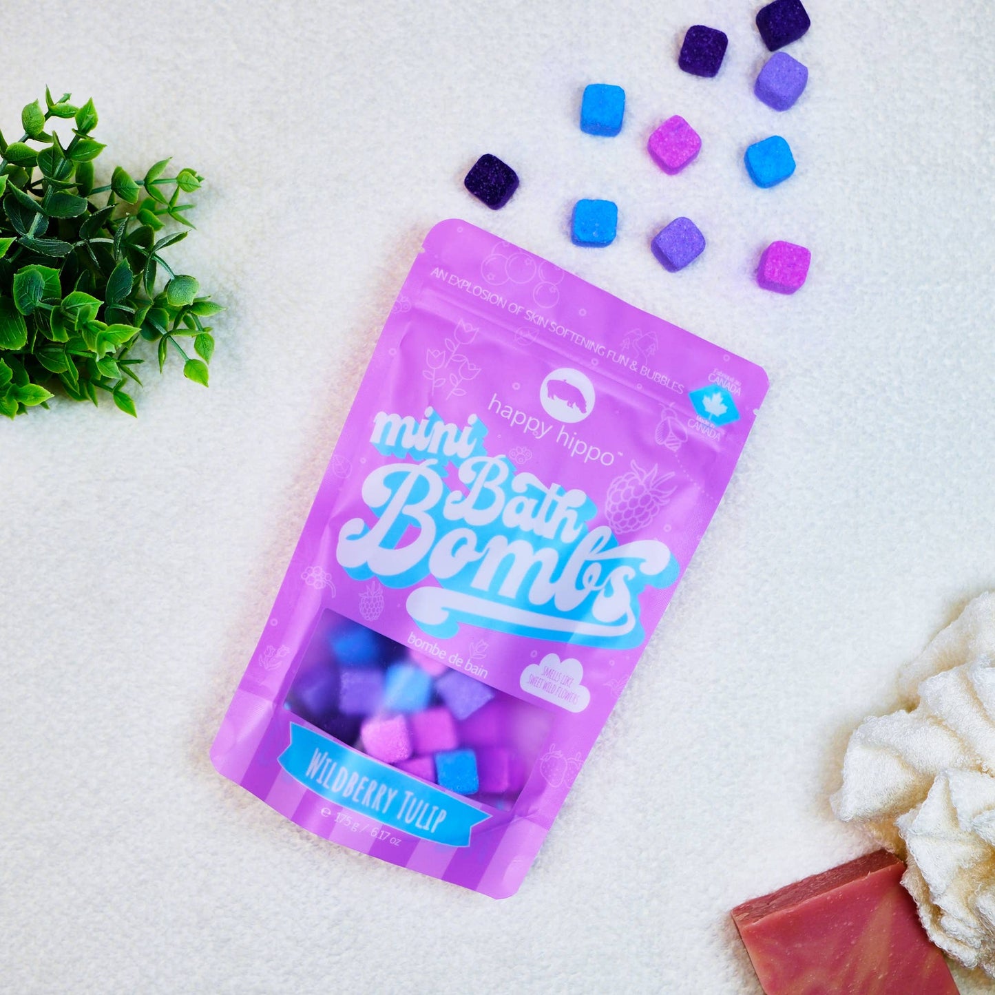 Purple package of bath bombs with colorful bath bombs on a white background.
