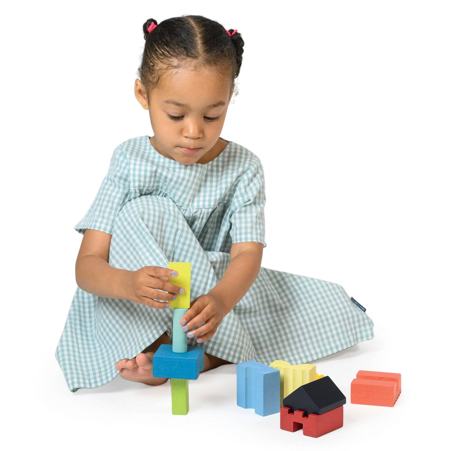 
                  
                    Child playing with colorful building blocks on a white background.
                  
                