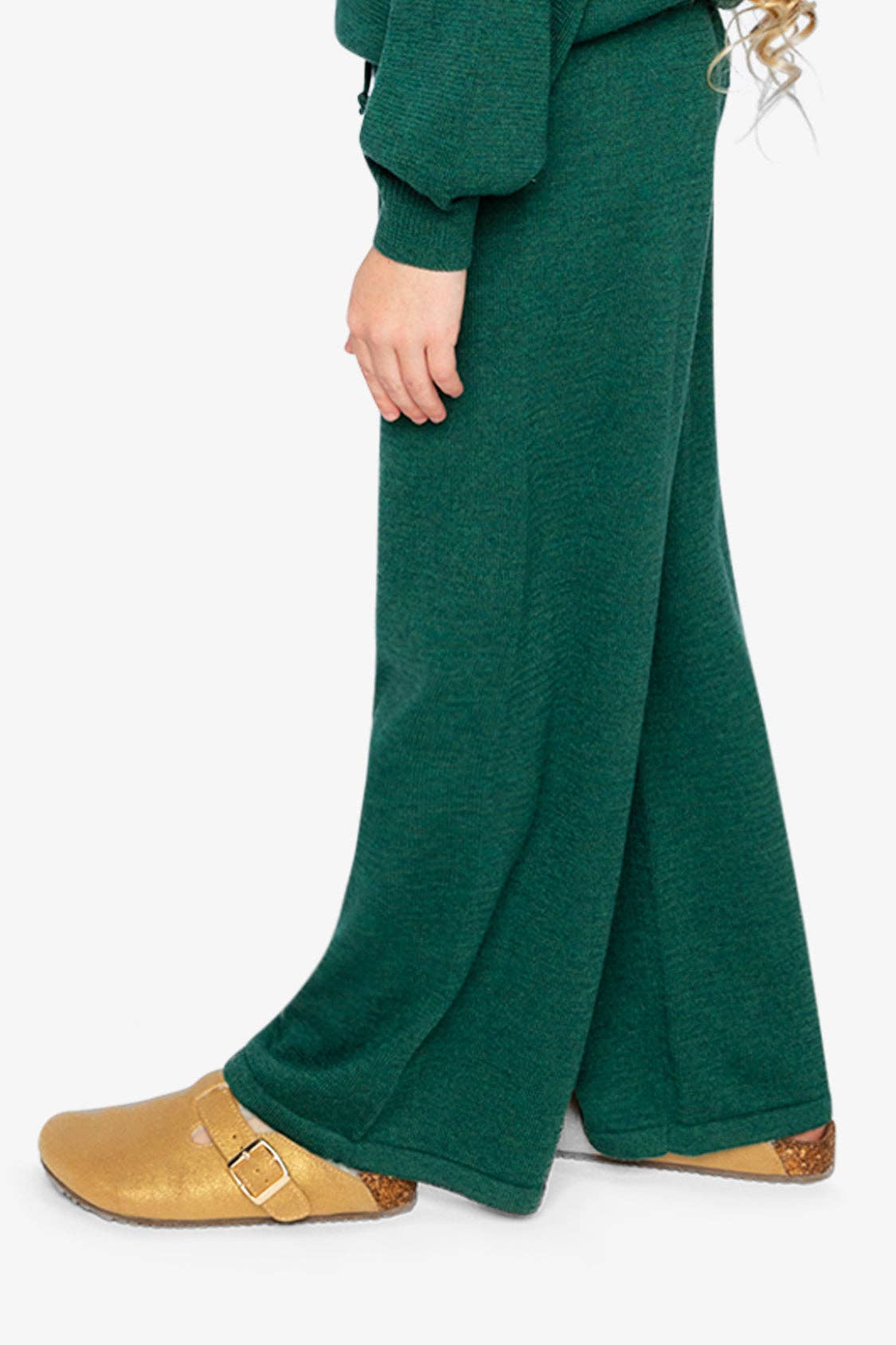 
                  
                    Green pants worn by a person on a white background.
                  
                