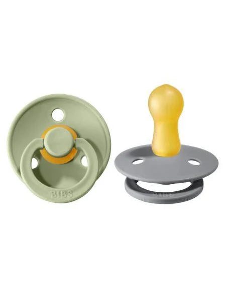 Two baby pacifiers, one green and one gray with yellow accents, on a white background.